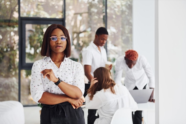 Hermosa mujer con gafas frente a sus colegas Grupo de empresarios afroamericanos que trabajan juntos en la oficina