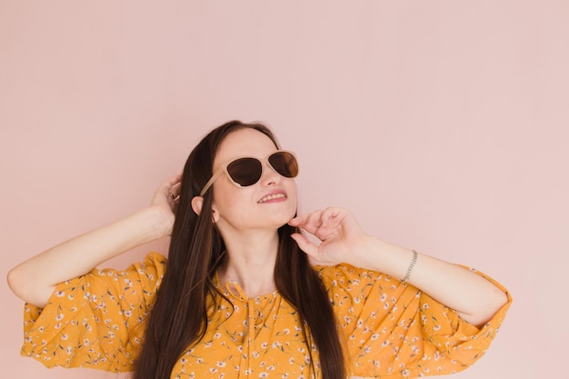 Hermosa mujer en gafas de sol sobre fondo rosa