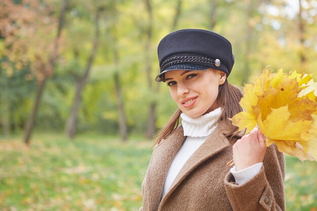 Hermosa mujer gentil en el parque de otoño