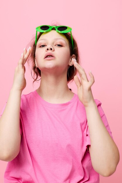 Hermosa mujer con gesto de decoración de gafas verdes con su estudio de manos