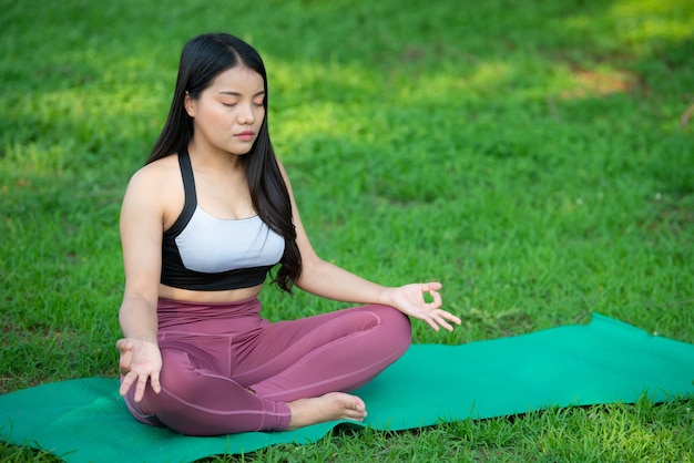 Hermosa mujer gorda asiática juega yoga en el parque Necesita adelgazar el cuerpo