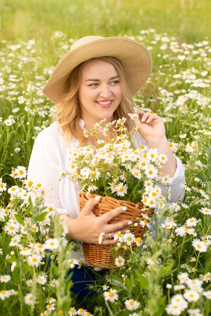 hermosa mujer gorda en un campo con margaritas y un sombrero