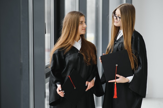 Hermosa mujer graduada destacándose de un grupo de estudiantes