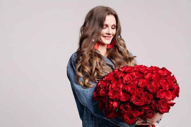 Hermosa mujer con grandes aretes con rosas y sonriendo