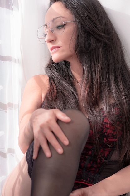 Hermosa mujer hispana disfrutando de su mañana cómoda en casa usando lencería roja