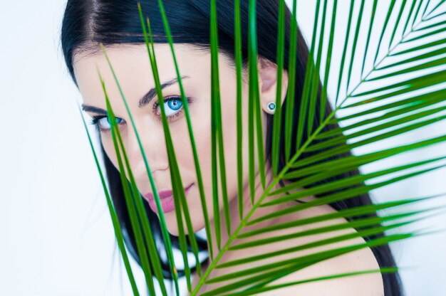 Foto hermosa mujer con hojas de palma