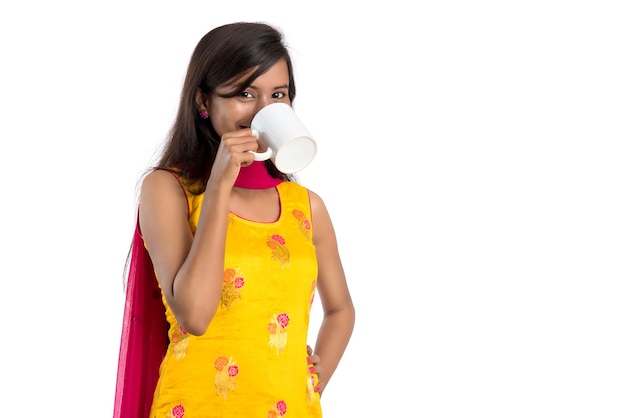 Hermosa mujer india vistiendo un tradicional sari bebiendo té