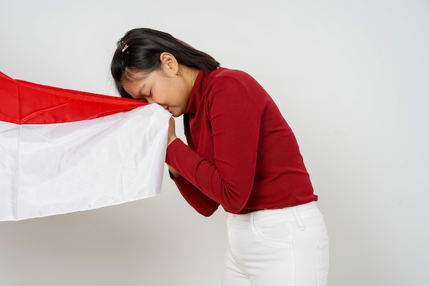 Hermosa mujer de Indonesia besando la bandera de Indonesia