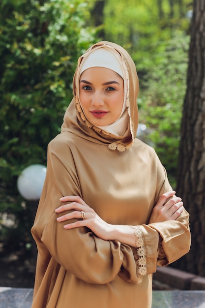 Foto hermosa mujer islámica en un vestido musulmán de pie en un parque de verano fondo de la calle bosque árboles otoñales