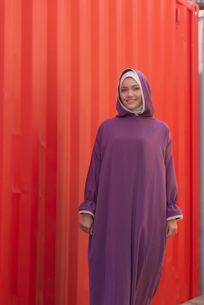 Hermosa mujer islámica en un vestido musulmán de pie en un parque de verano, fondo de la calle, bosque, otoño, árboles. Día mundial del hijab.