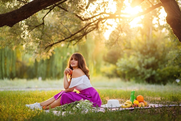 Hermosa mujer en el jardín con diferentes frutas.