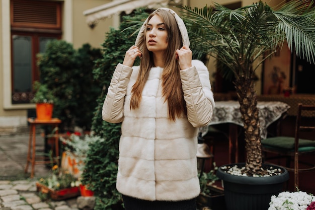 Hermosa mujer joven con un abrigo de capucha en invierno