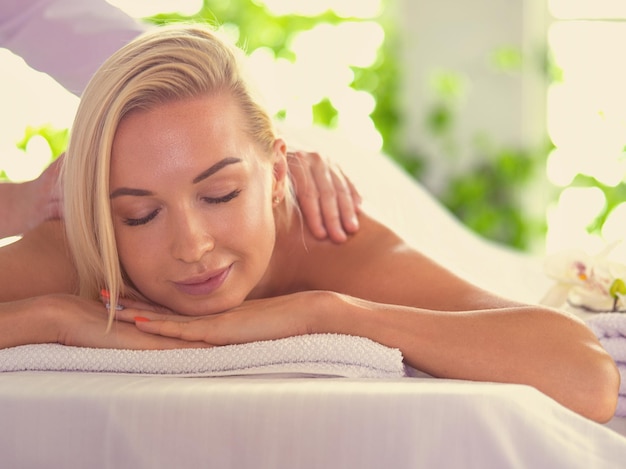 Hermosa mujer joven acostada en el salón de spa