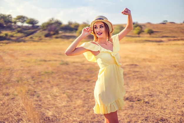 Hermosa mujer joven al aire libre en la colina en un día de verano