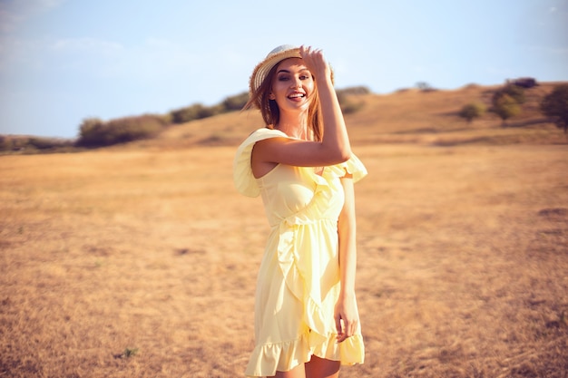 Hermosa mujer joven al aire libre en la colina en un día de verano