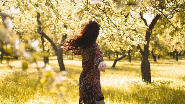 Hermosa mujer joven al aire libre. Disfruta de la naturaleza. Niña sonriente sana en el parque de la primavera. Día soleado