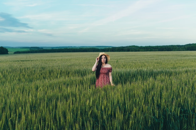 Hermosa mujer joven al atardecer en el campo