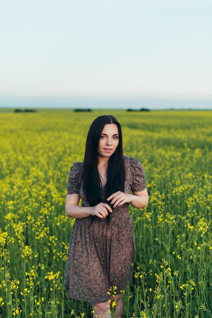 Hermosa mujer joven al atardecer en el campo