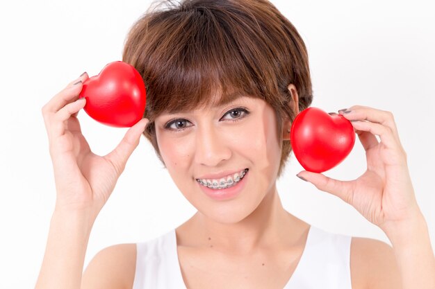 Hermosa mujer joven de asia con corazones rojos.