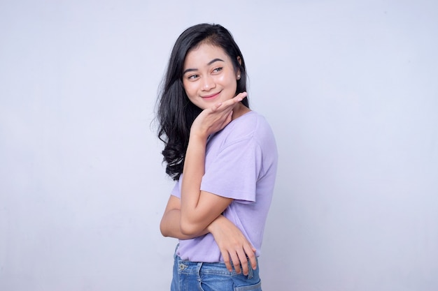 Hermosa mujer joven de aspecto amable positivo con cabello negro encantadora sonrisa sincera que se siente agradecida y agradecida sobre fondo blanco claro