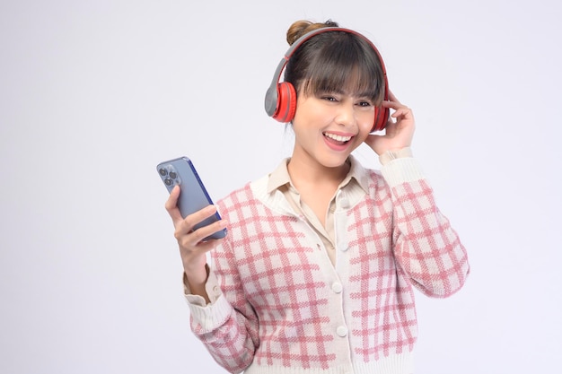 Hermosa mujer joven con auriculares sobre fondo blanco.