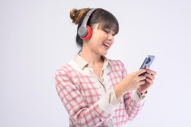 Hermosa mujer joven con auriculares sobre fondo blanco.