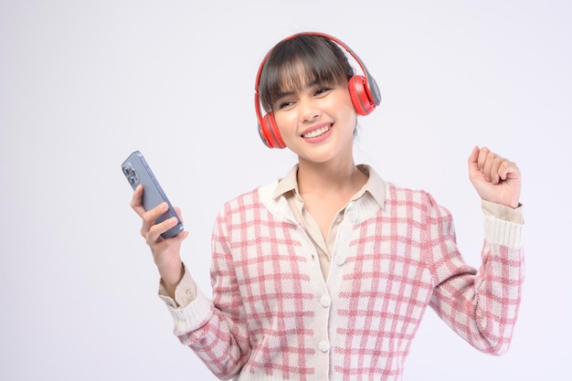 Hermosa mujer joven con auriculares sobre fondo blanco.