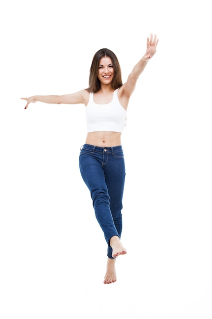 Hermosa mujer joven bailando sobre fondo blanco.