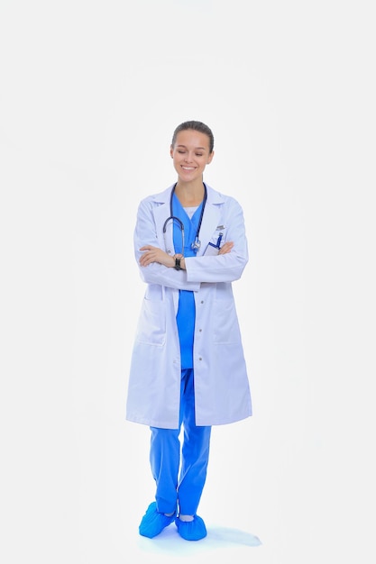 Hermosa mujer joven en bata blanca posando con la mano en el bolsillo. Doctora