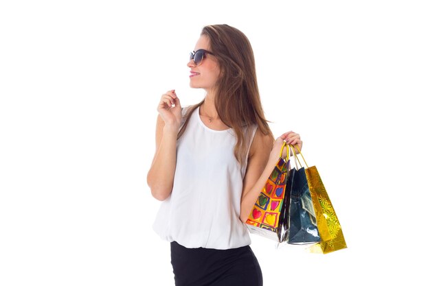 Foto hermosa mujer joven en blusa blanca y falda negra con gafas de sol oscuras con bolsas de compras