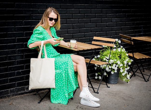 Hermosa mujer joven con bolsa ecológica de lino en el fondo de la ciudad
