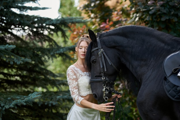 hermosa mujer joven con un caballo negro