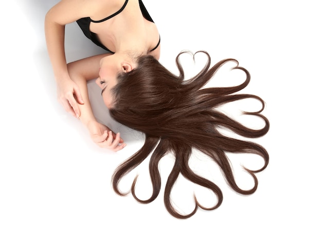 Hermosa mujer joven con cabello en forma de corazones en blanco