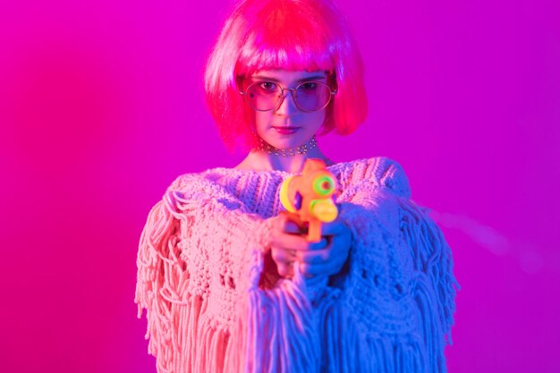 hermosa mujer joven con cabello rosado y lentes de plátano dorado posando en un espectacular estilo neón