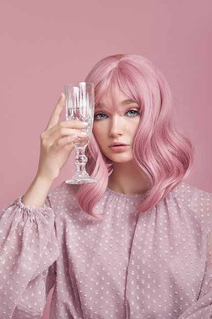 Hermosa mujer joven con cabello rosado con un vestido