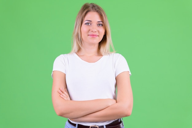 Hermosa mujer joven con cabello rubio en clave de croma en verde