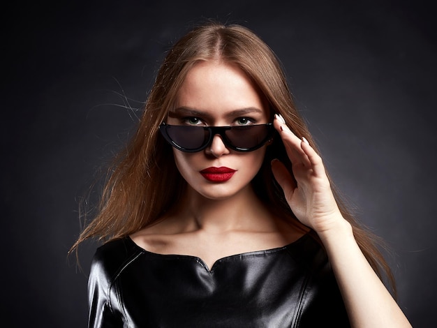 Hermosa mujer joven con cabello sano en gafas de sol