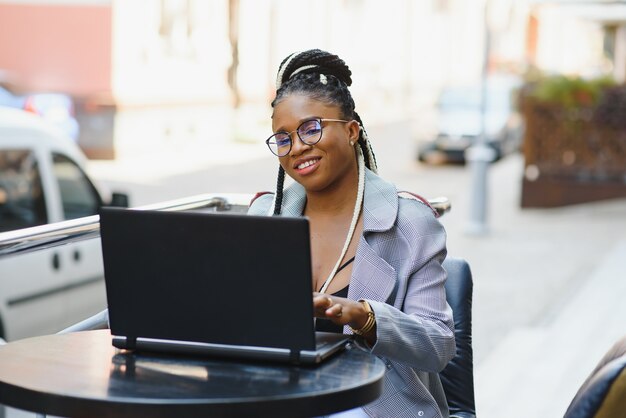 Hermosa mujer joven en un café usando una computadora portátil