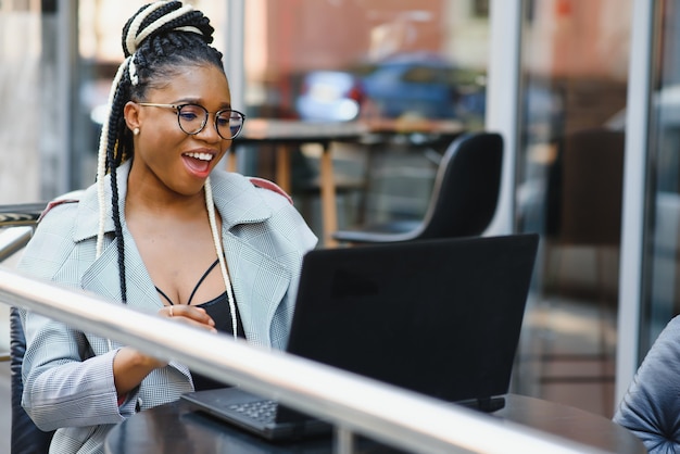 Hermosa mujer joven en un café usando una computadora portátil