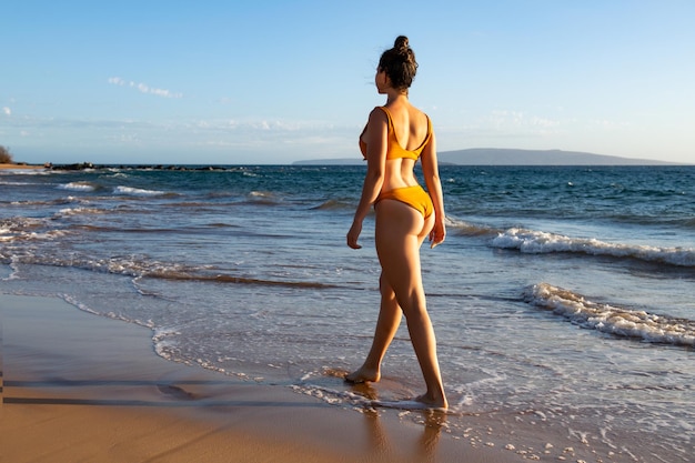 Hermosa mujer joven caminando en el mar en la playa de arena, viajes de verano, playa y mar de verano