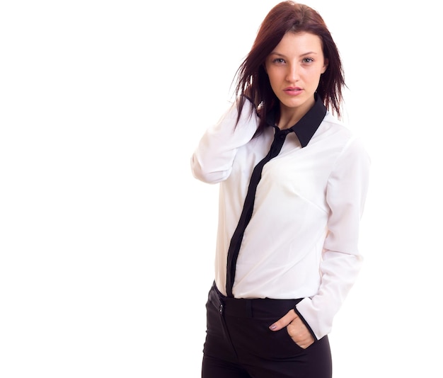 Foto hermosa mujer joven con camisa blanca y pantalón negro con cabello oscuro sobre fondo blanco en el estudio