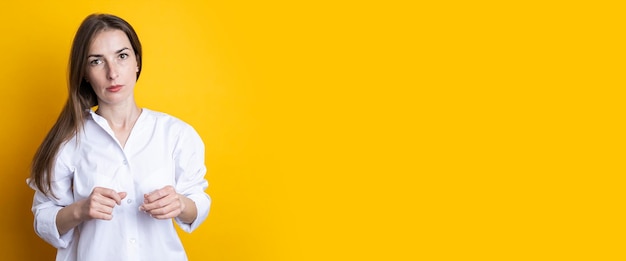 Hermosa mujer joven en una camisa blanca sobre un fondo amarillo Banner