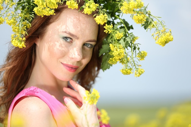 Hermosa mujer joven en campo de flores