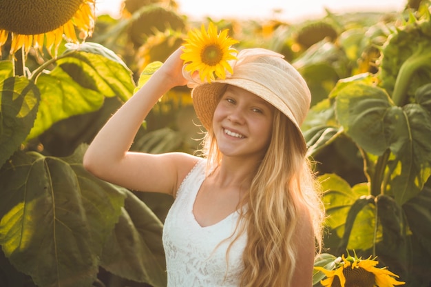 Hermosa mujer joven en un campo de girasoles. Retrato de una mujer joven al sol. Concepto de alergias al polen