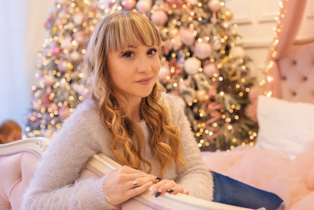 hermosa mujer joven cerca del árbol de navidad en navidad en casa