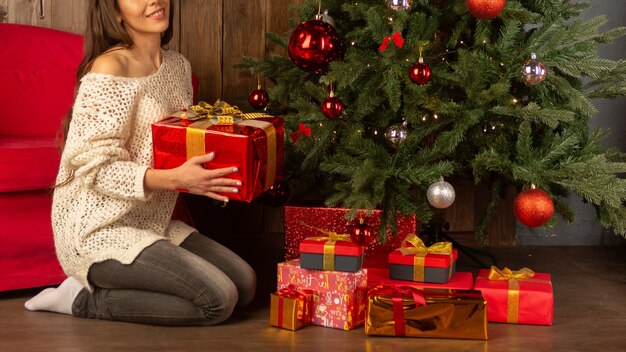 Hermosa mujer joven cerca de un árbol de Navidad