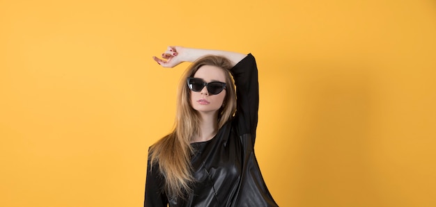 Hermosa mujer joven en chaqueta negra y gafas de sol negras