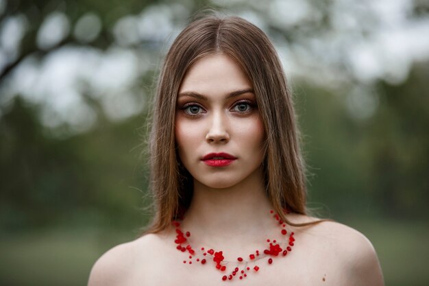 Hermosa mujer joven con un collar rojo