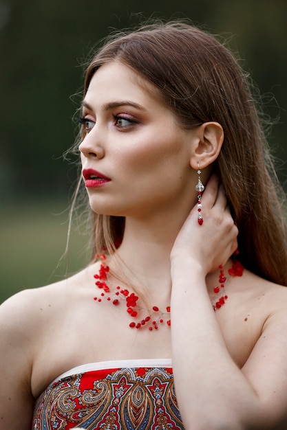 Hermosa mujer joven con un collar rojo