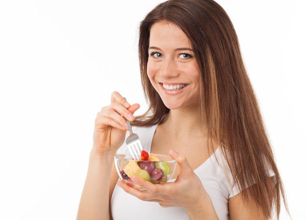 Foto una hermosa mujer joven comiendo frutas